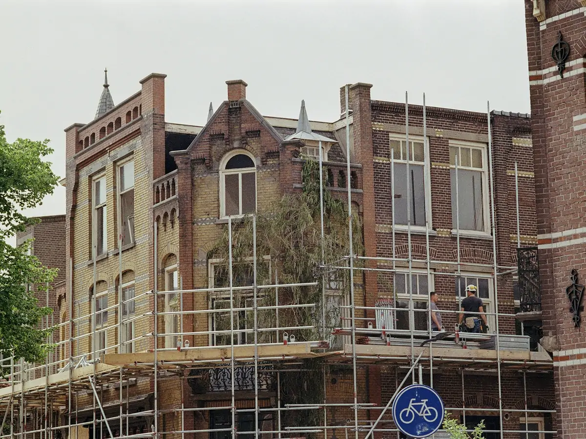 _PENDIENTE — foto real del proyecto. Provisional: fachada de edificio protegido con andamio de rehabilitación montado.
